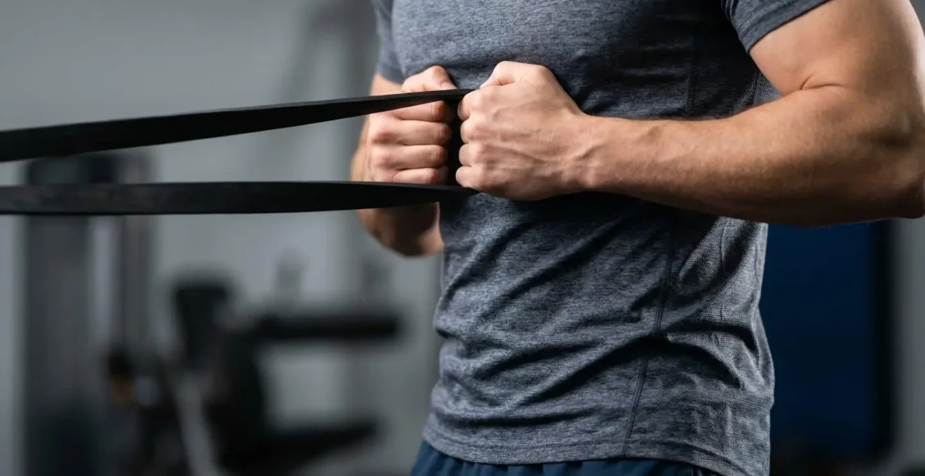 Athlete pratiquant un exercice de gainage anti-rotation avec elastique pour equilibrer les muscles du tronc