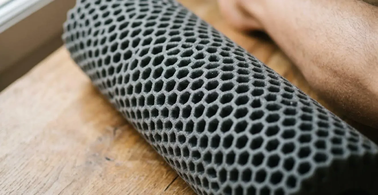 Gros plan sur rouleau de massage en mousse texturé avec mise au point sur la structure cellulaire du matériau
